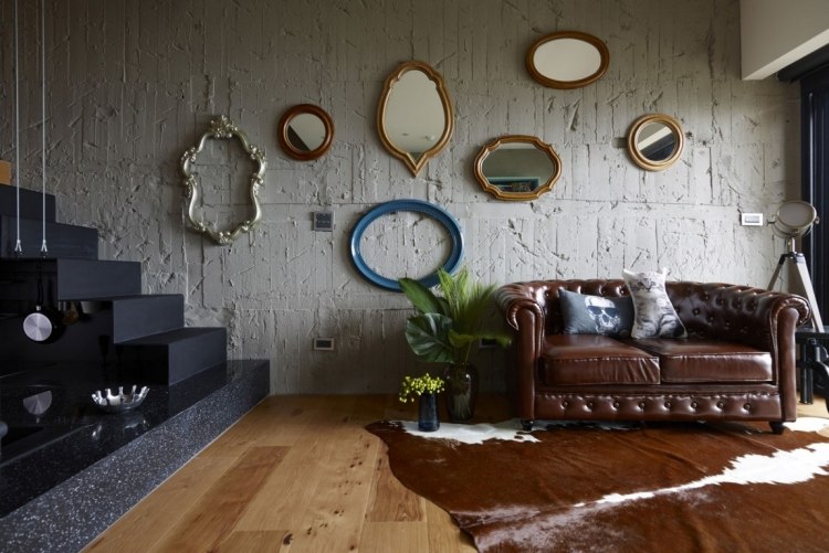 Im Stilmix wohnen -einrichtung-einzimmerwohnung-betonwand-rau-spiegel-fellteppich-chesterfield-sofa