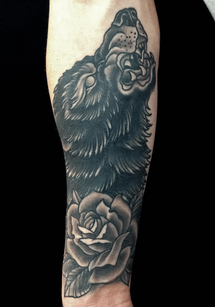 wolf tattoo wolfskopf Unterarm schwarz design aggressiv blume akzent