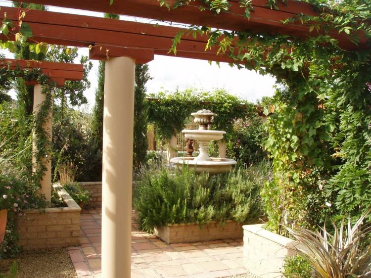 Mediterraner Garten gartengestaltung-immergruene-pflanzen-weinstock-blumen-steinbrunnen-skulptur