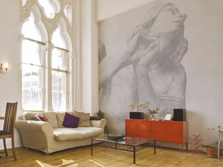 tapete-im-wohnzimmer-caelestis-antik-wandbild-idee-frau-moebel-beige-couch-orange-sideboard