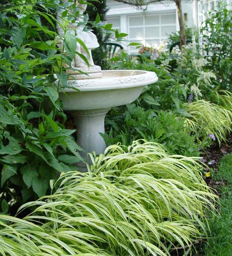 Ideen-Gartengestaltung-japanisches-gras-bueschel-hellgruene-beete-blattschmuckpflanze-busche-gartenfontaene