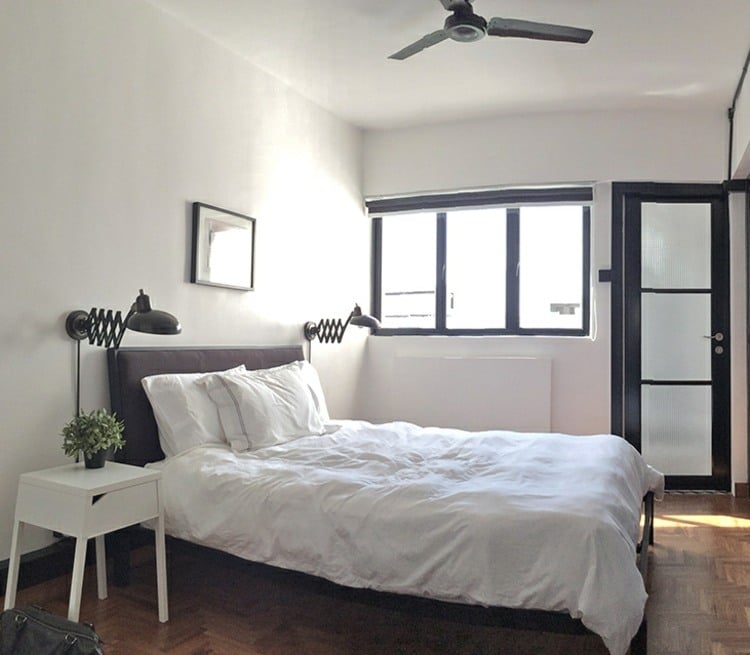 kleine-wohnung-einrichten-schlafzimmer-schwarz-polsterbett-nachttisch-weiss-parkettboden