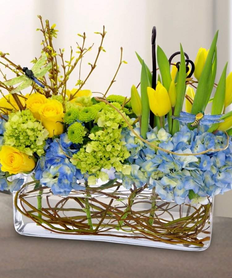 Glasvasen dekorieren fruehling-eckige-niedrige-vase-fruehling-osterdeko-gelbe-tulipen-rosen-blaue-hortensie-forsythien-zweige-sichtbare