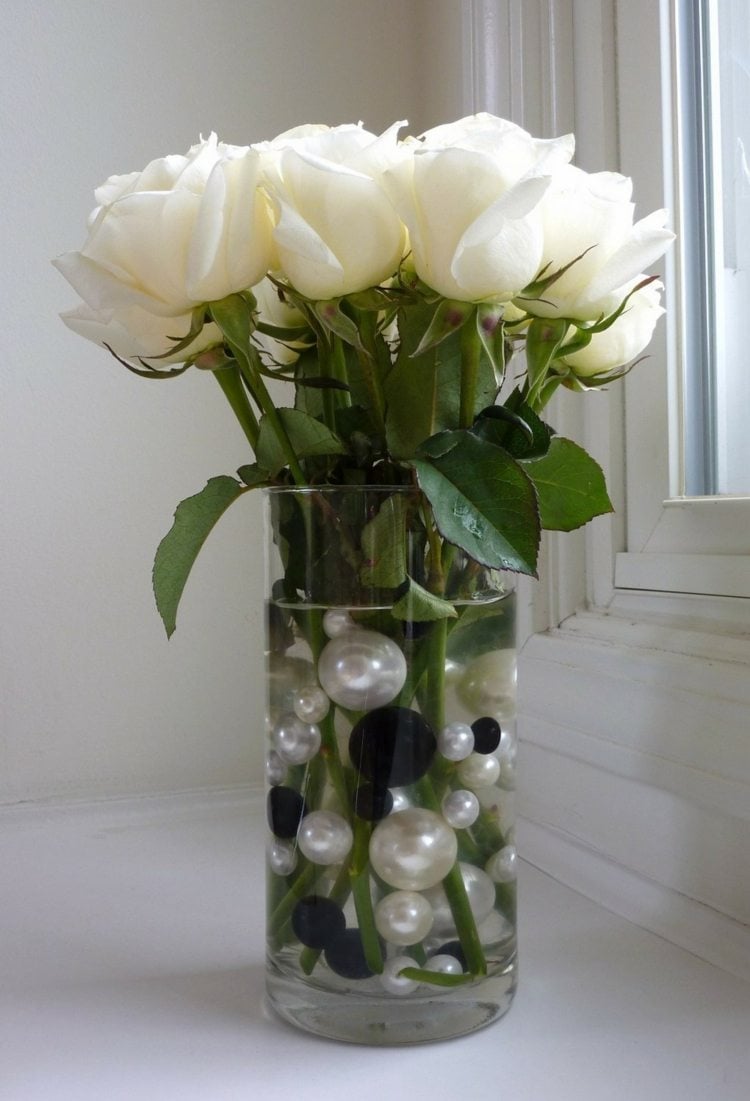 Glasvasen-dekorieren-fruehling-hohe-runde-bodenvase-weisse-rosen-grosse-wasser-perlen-schwarz