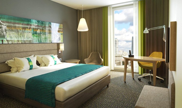 erstklassige-raumkonzepte-hotel-suite-graue-wandfarbe-wandbild-beige-polsterbett-smaragdgruene-akzente-teppichboden