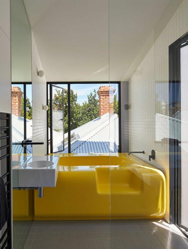 gelb-badezimmer-badewanne-futuristisch-abgerundet-fensterfront-schwarz-akzente