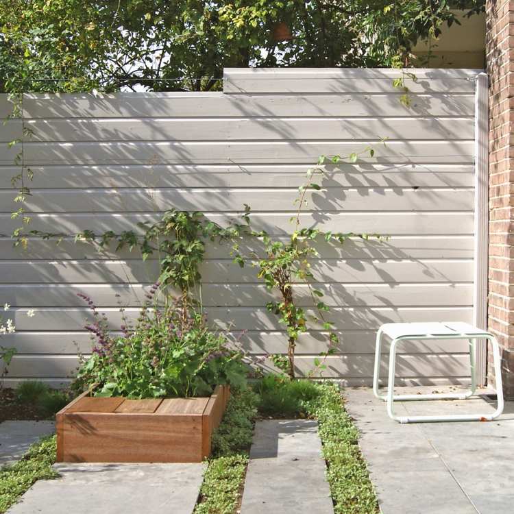 sichtschutzzaun-holz-holzarten-weiss-kletterpflanzen-terrassenplatten-beton