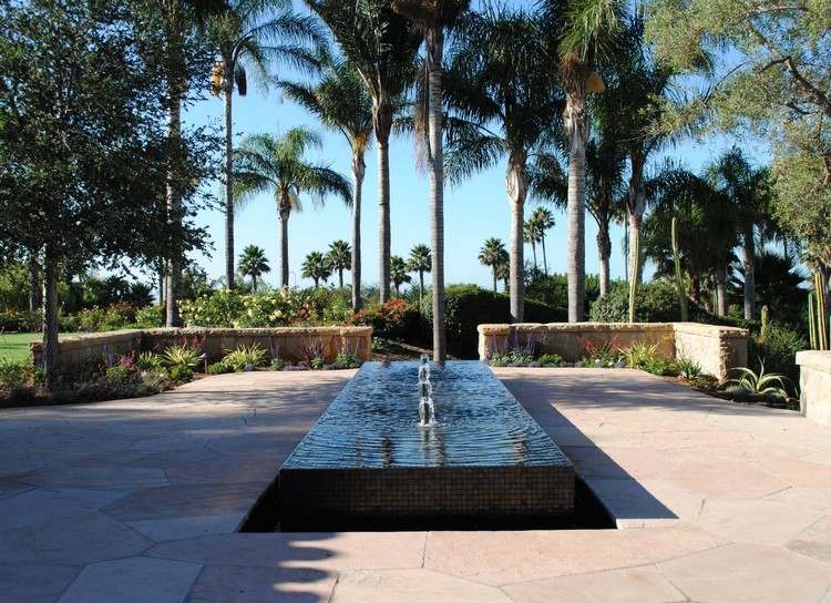 Wasser im Garten bachlauf-brunnen-natursteinplatten-palmen