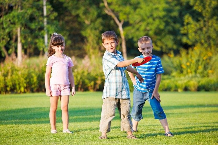 Kinderspiele im Garten rotes-frisbee-werfen-freunde-sommertag