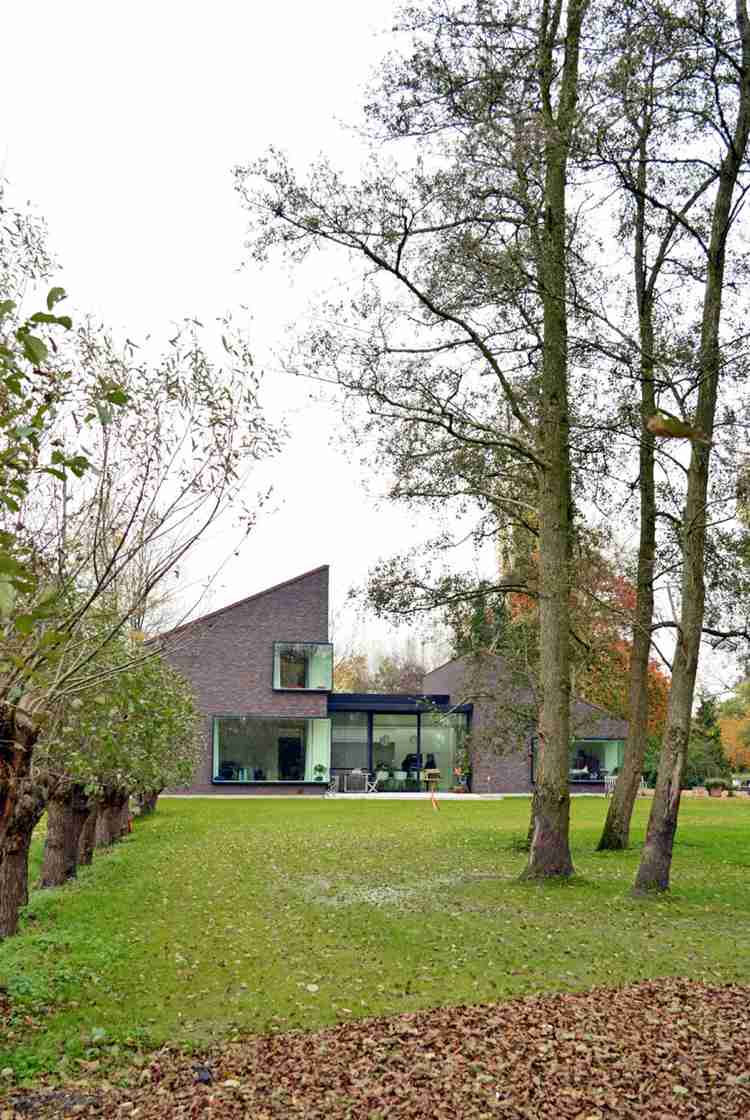 moderne-klinkerfassade-einfamilienhaus-natur-landschaft-grundstueck-rasen