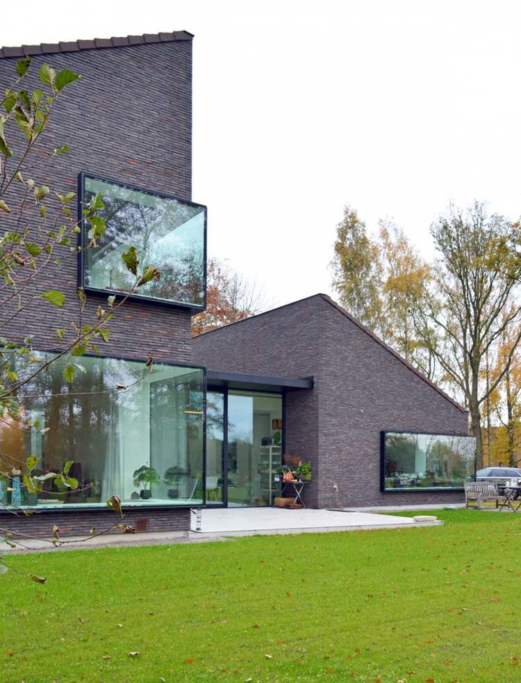 moderne-klinkerfassade-einfamilienhaus-panoramafenster-grundstueck-rasen-natur-landschaft