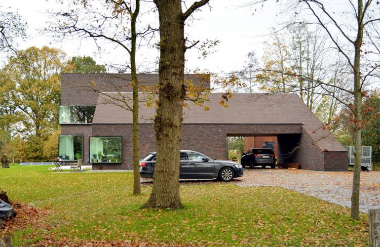 moderne-klinkerfassade-grundstueck-garage-parkplatz-landschaft-natur