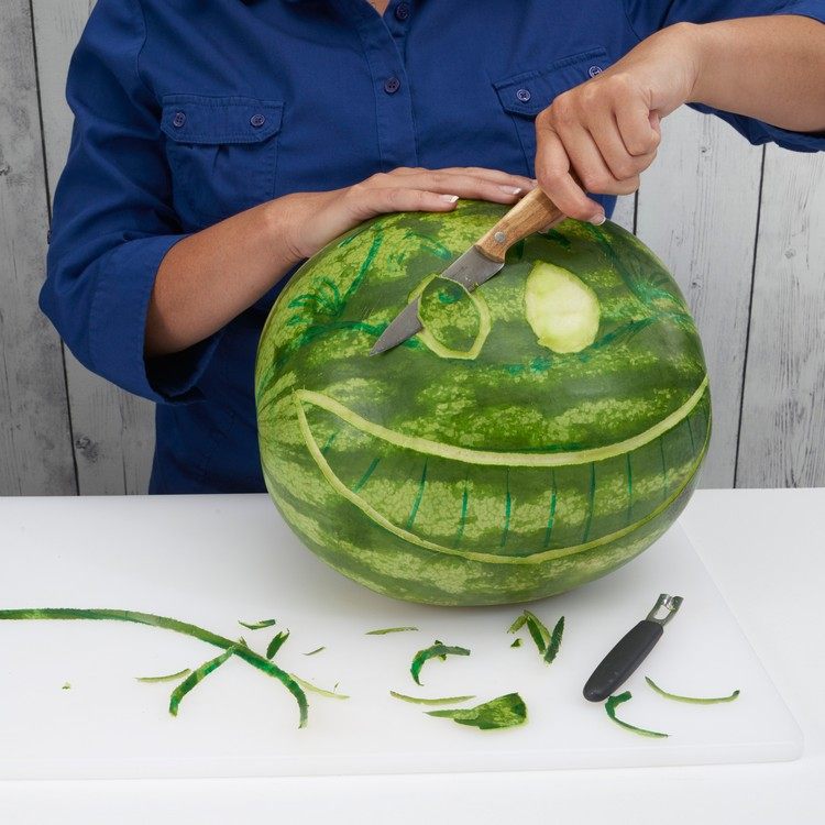 Wassermelone schnitzen grinsekatze-augen-formen-ausschneiden-gemüsemesser