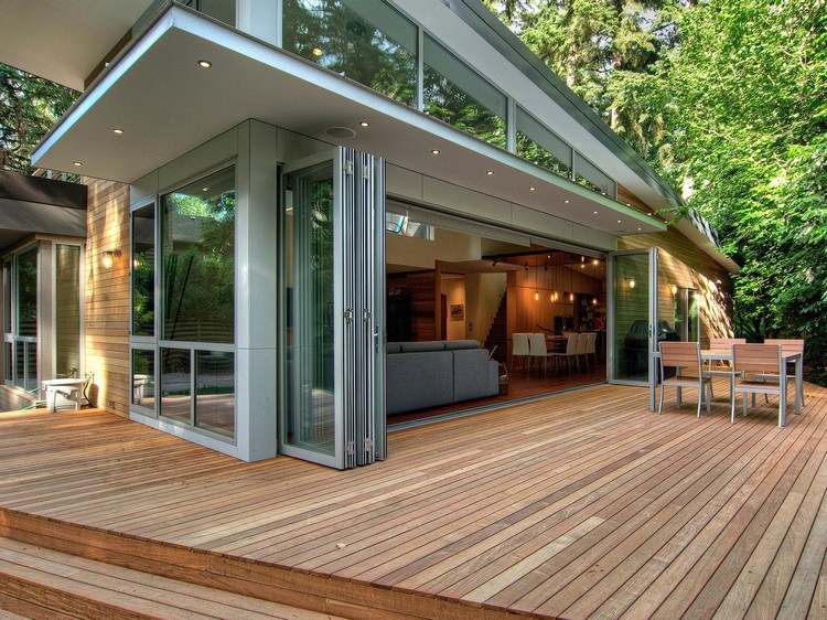 Glasfalttüren für Terrasse aussenansicht-graue-fensterrahmen-holzboden-holz-fassadenverkleidung
