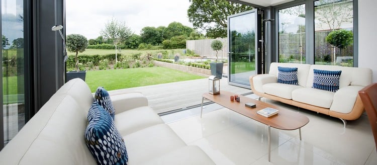 glasfalttüren-wintergarten-moderner-anbau-aluminium-falttüren-elegante-möbel-weiss