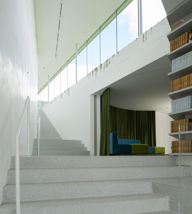 Moderne Glasfront -begrünung-treppe-beton-glasgeländer-buecherregale