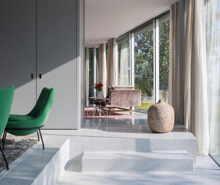 moderne-glasfront-wohnzimmer-betonboden-pastellfarben-gardine