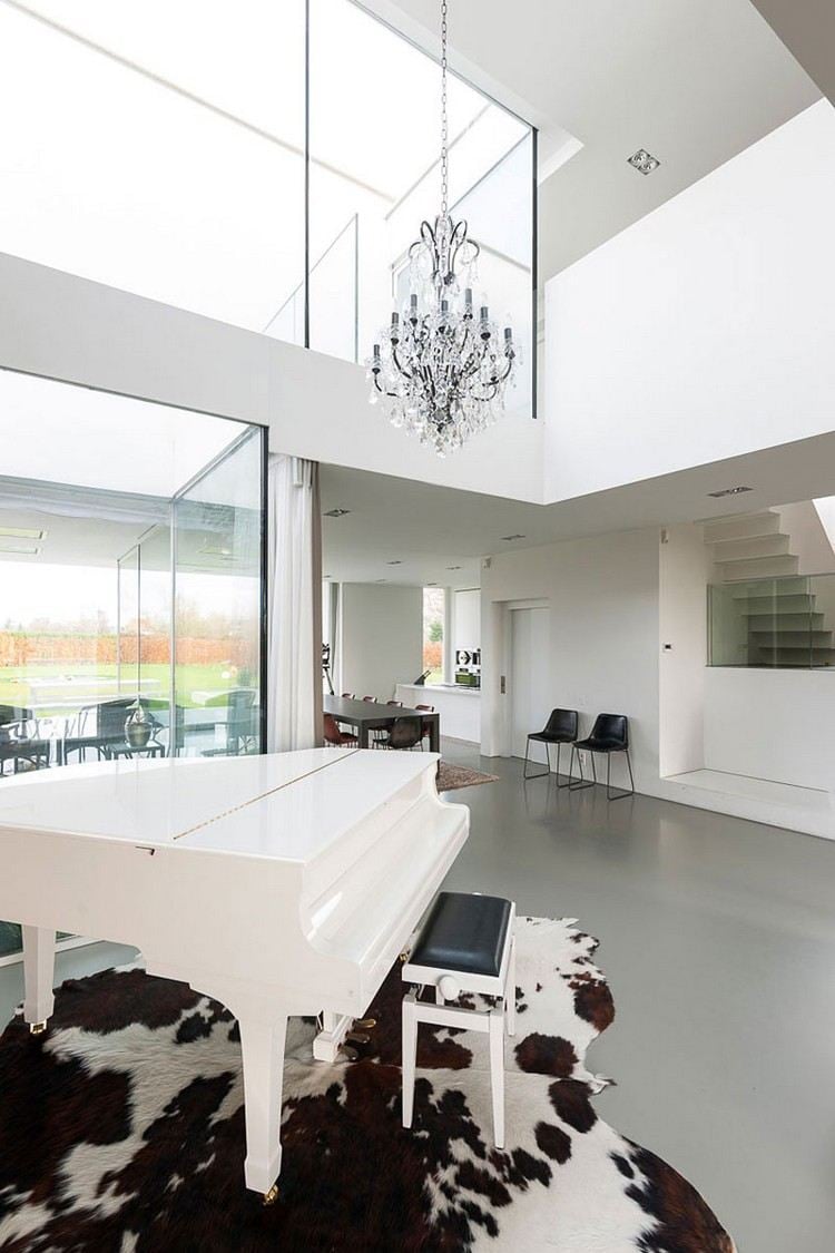 moderne-innenarchitektur-einfamilienhaus-große-fenster-weißes-klavier-kuhfell-teppich