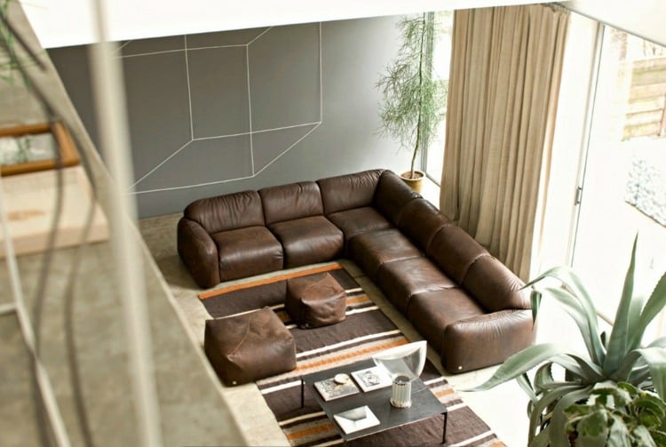 wohnzimmer-ideen-brauner-couch-leder-beige-vorhaenge-teppich-streifen-grau-akzentwand