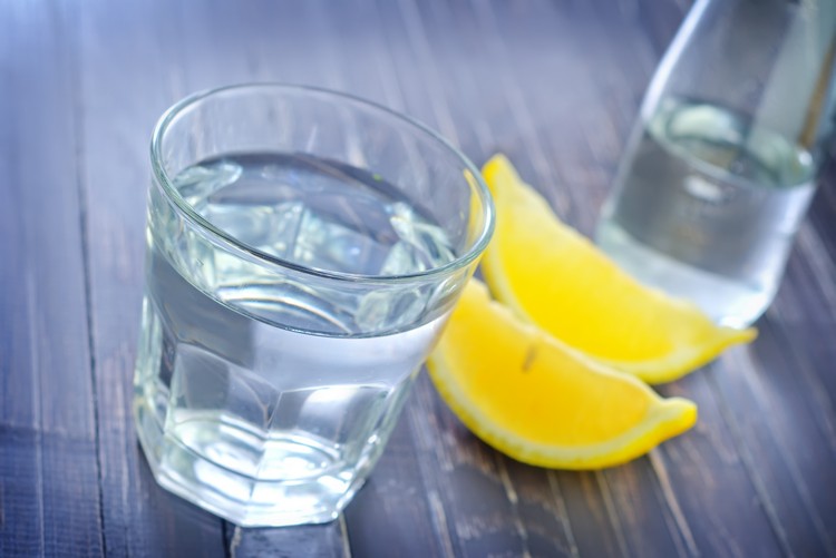 Zitronenwasser Diät abnhemen-glas-flasche-wasser-zitronenviertel-tisch