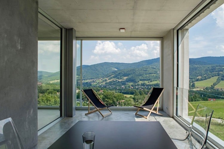 beton-design-innen-betonhaus-terrasse-klapstuehle-holz-glasgelaender
