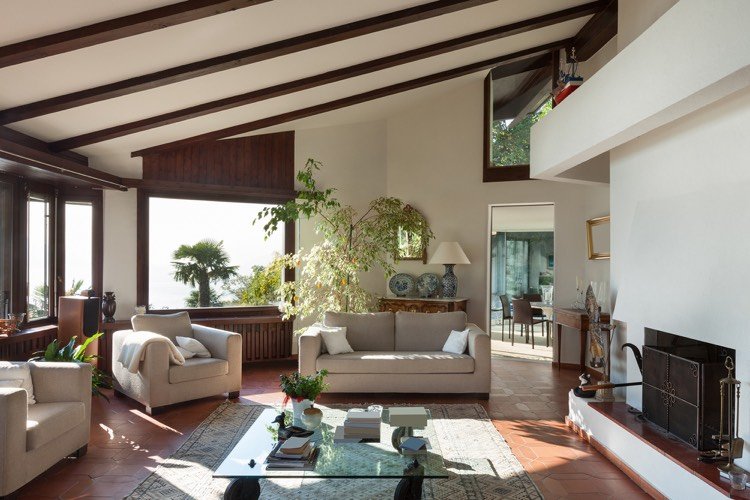 landhausstil-wohnzimmer-italienisch-terrakotta-bodenfliesen-holz-wandpaneele-dachschräge