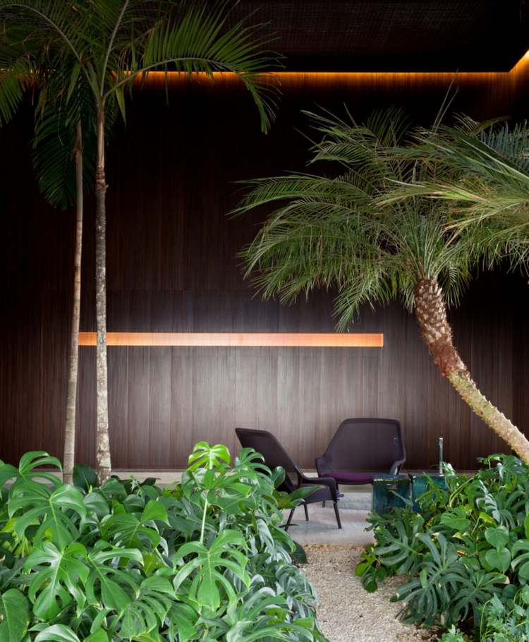wohnzimmer-regalwand-wandverkleidung-holz-palmen-pflanzen-tropisch
