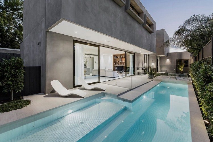 Betonhaus mit Pool minimalistisch-sonnenliegen-garten-pflanzen