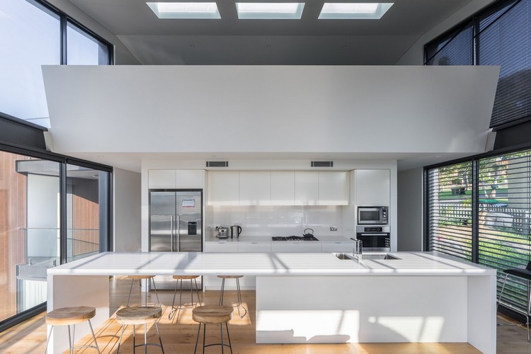 große-fensterfronten-mehr-licht-dachfenster-weiße-küche-kücheninsel