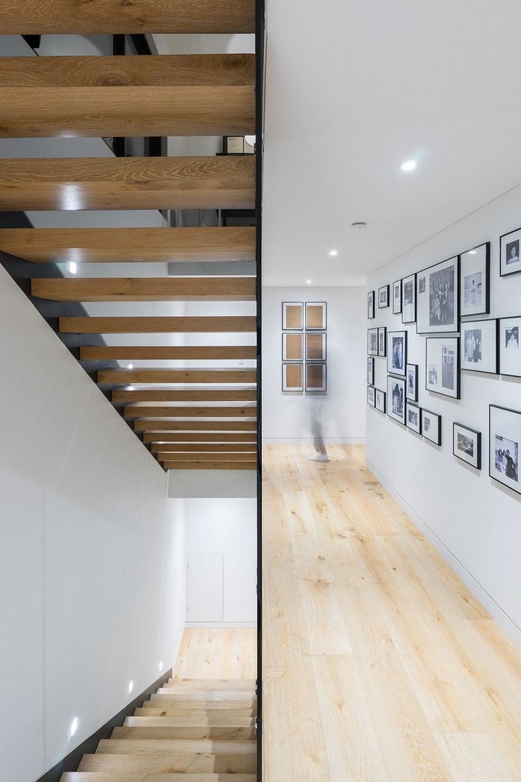 innendesign-einfamilienhaus-treppenbereich-holztreppe-wandbilder
