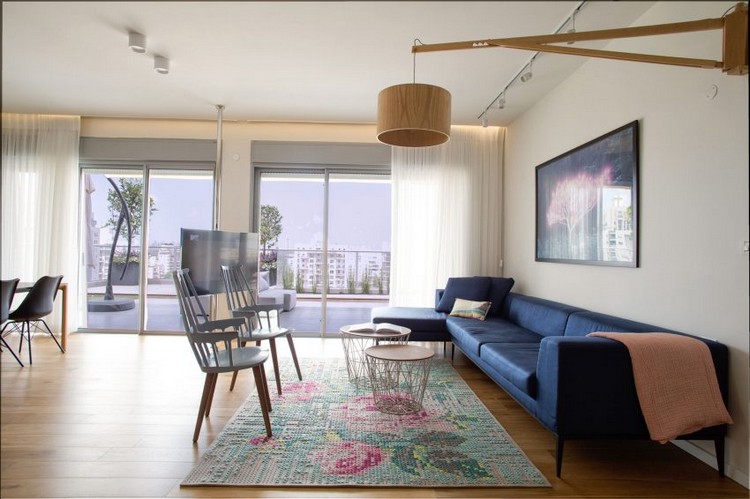 wohnzimmer-blaues-sofa-hängelampe-holz-terrasse-vorhänge-ausblick