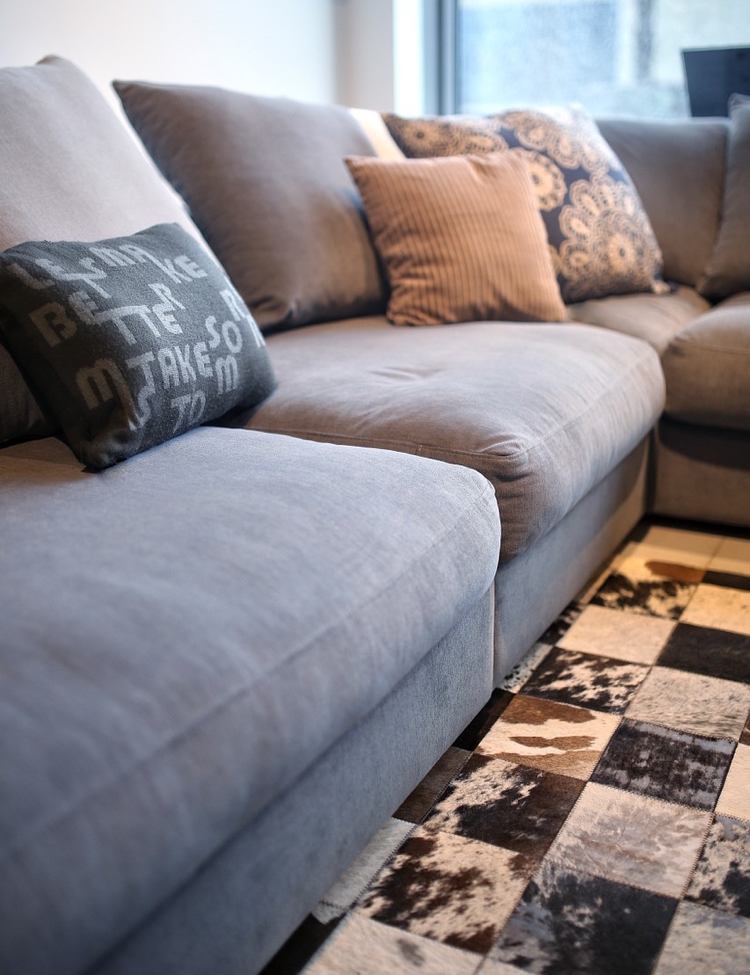 einrichtungstipps-wohnzimmer-teppich-couchgrau-kissen-modern-einrichten