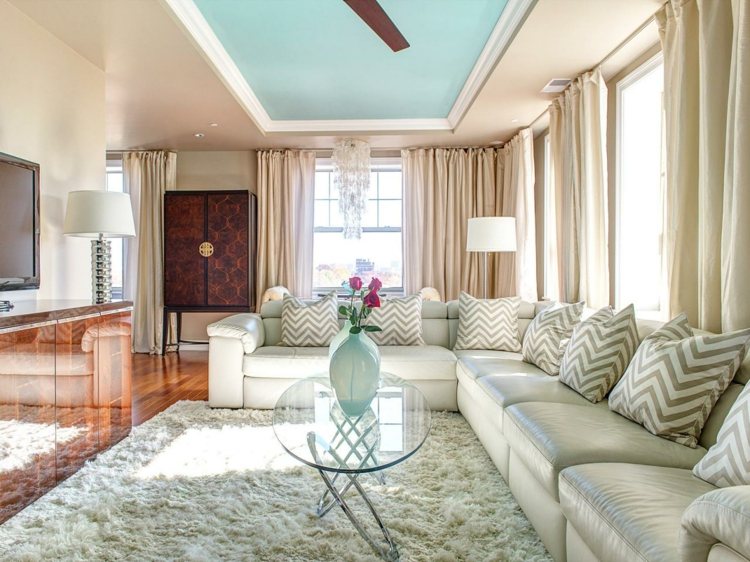 wohnzimmer-renovieren-couch-leder-kissen-muster-zickzack-decke-farbig-minze-gardinen-beige-glastisch