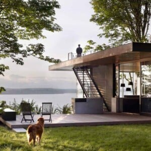 gartenhaus-terrasse-dachterrasse-treppen-aussicht-see-stühle-holzpodest-hund-mann-natur-bäume-pendelleuchten