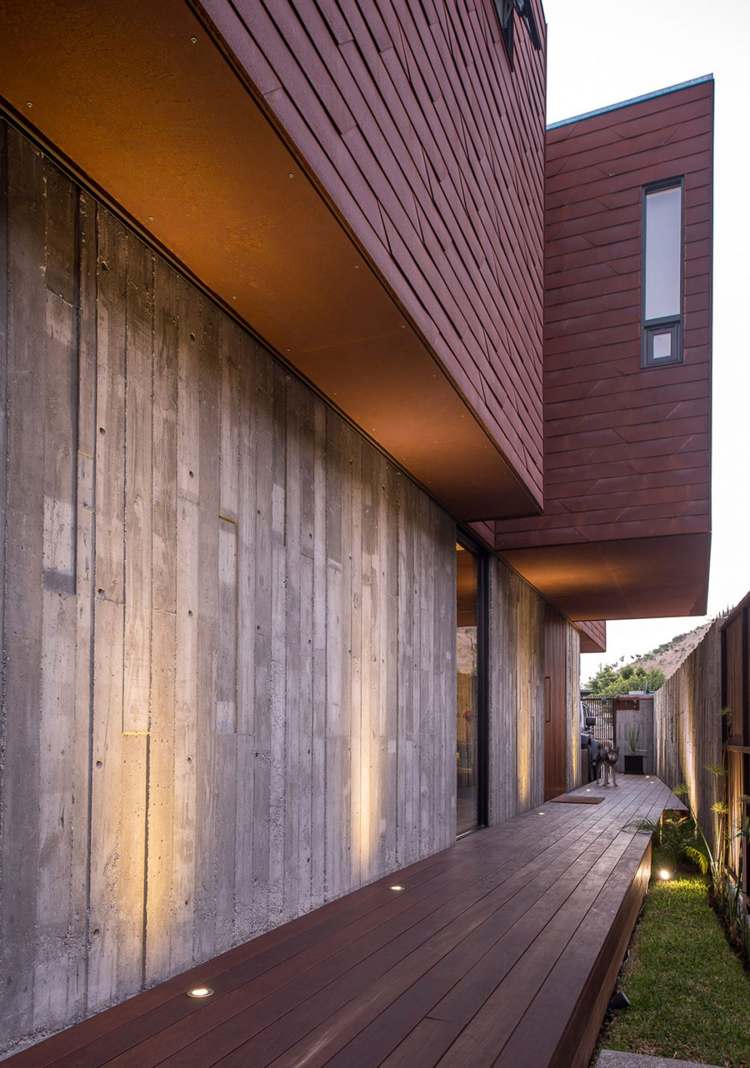moderne-fassadenverkleidung-rotbraun-paneele-beton-terrasse-holzdielen-beleuchtung