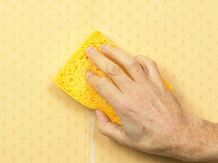 tapeten-überstreichen-vorbereiten-reinigen-staub-entfernen-schwamm-gelb-gemustert-hand-mann