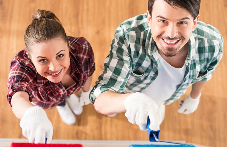 tapeten-überstreichen-mann-frau-renovieren-streichen-farbroller-rot-blau-wandgestaltung-parkettboden