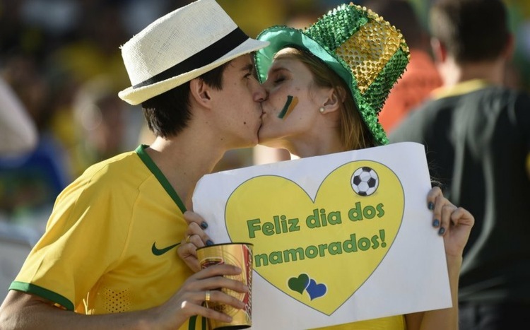 valentinstag bräuche brazilien-paar-mann-frau-kuss-fussball-schrift-schild-herzen-tshirt-gelb-grün-hut-farbig