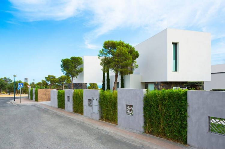 weiße-hausfassade-betonmauer-bepflanzung-hecken
