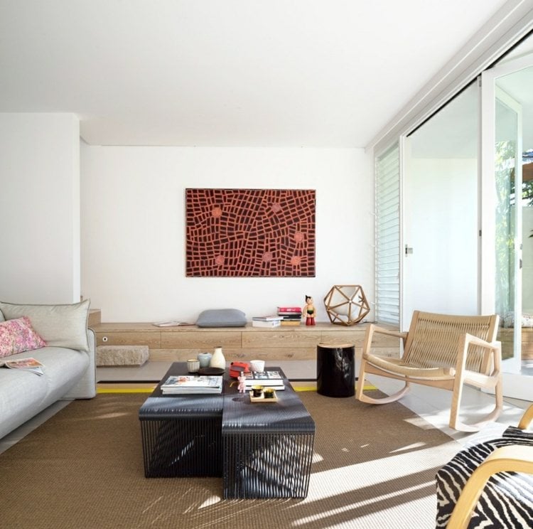 wohnzimmer-ohne-fernseher-beige-teppich-lounge-korbmöbel-wandbild-couchtisch