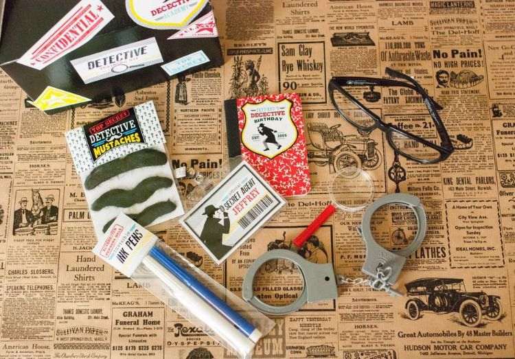 detektivparty-kindergeburtstag-zubehör-handschellen-heft-filzstifte-luppe-brille-karton-ausweis-schnurbart-zeitungen