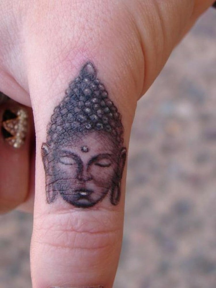 finger-tattoo-buddha-figur-frauenhand-nagellalck-daumen