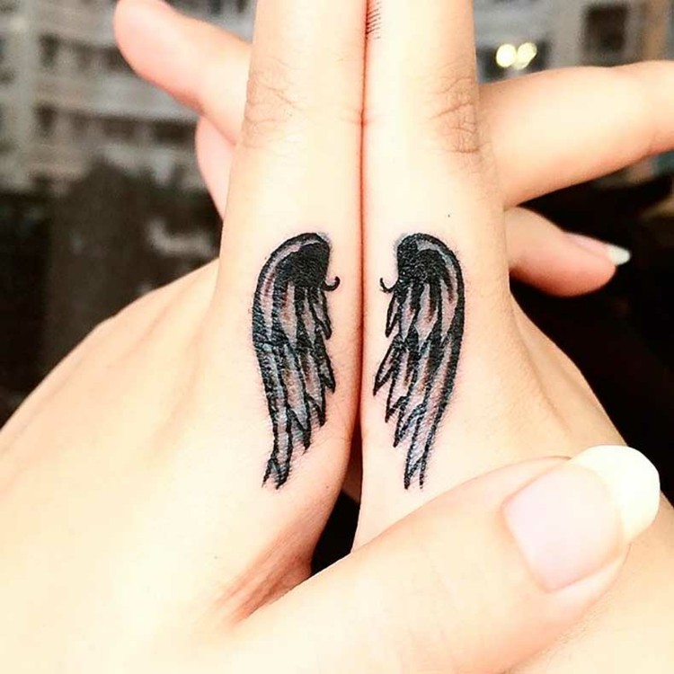 finger-tattoo-engelsflügel-schwarz-zeigefinger-frauenhände-seitlich