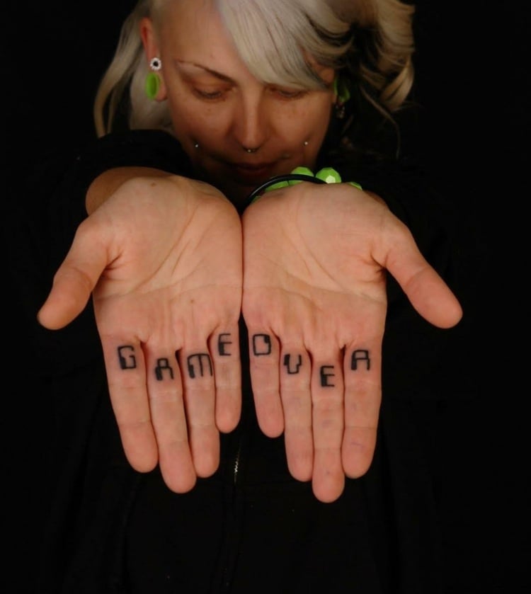 finger-tattoo-frau-handfläche-finger-innen-schrift-schwarz-groß