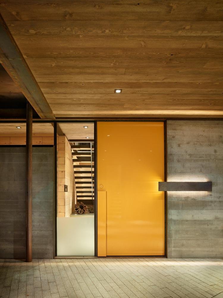 industrial-style-möbel-eingangstür-farbakzent-gelb-beton-fassade-überdachung