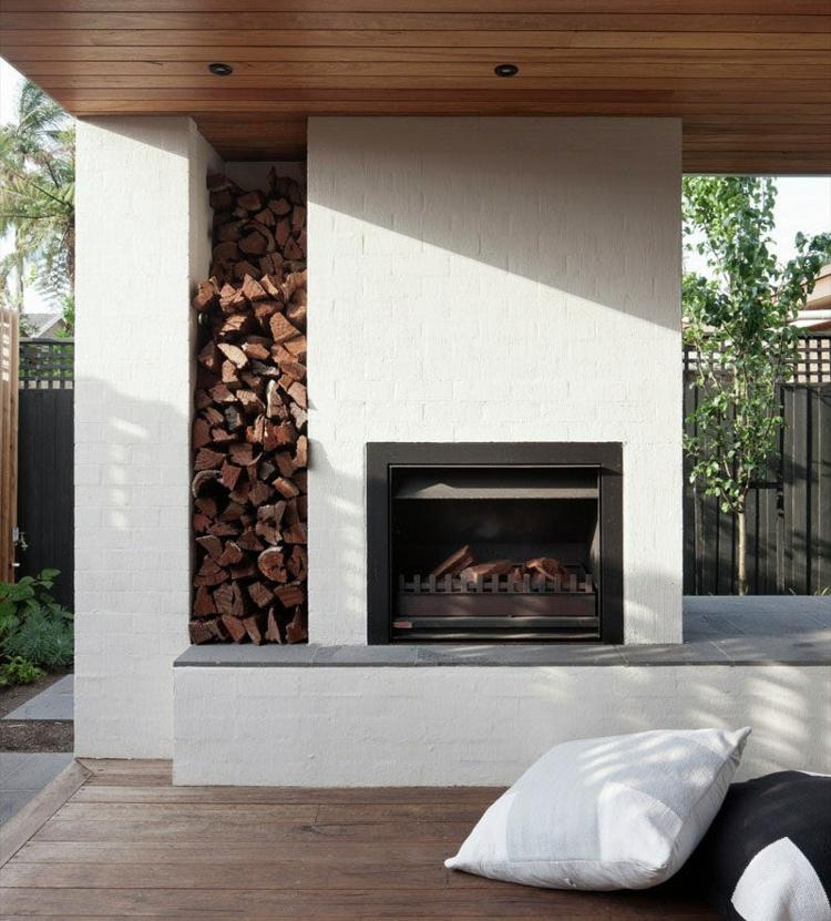 moderne-terrassen-kamin-gartengestaltung-ideen-feuerholz-regal-backstein-weiß