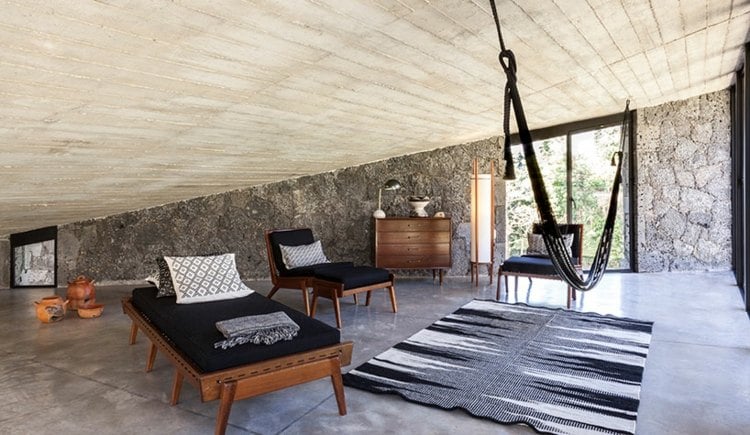 naturstein wand raumgestaltung-betondecke-liegestühle-chaiselonge-teppich