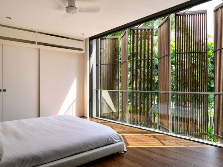 offenes-wohnzimmer-fensterläden-modern-holzlamellen-bett-schlafzimmer-holzfußboden