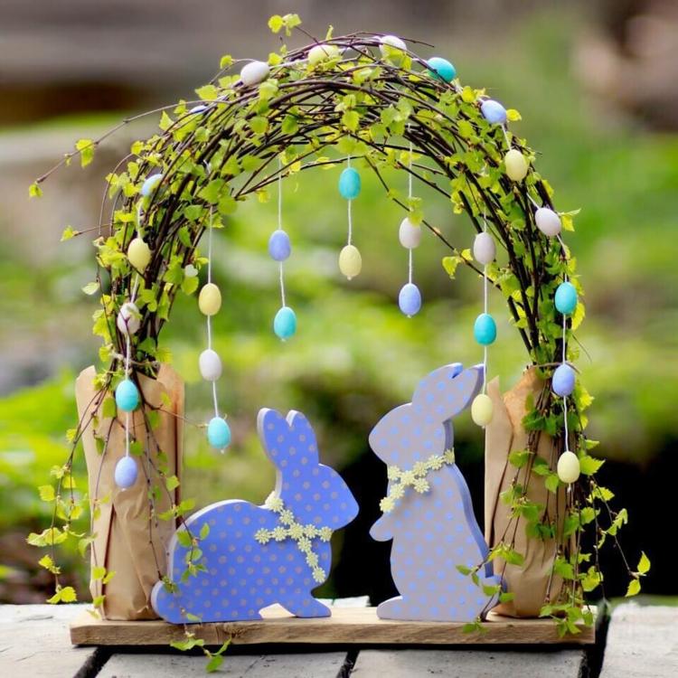 Einen dekorativen Bogen für den Tisch mit Zweigen und Girlanden aus Mini-Eiern