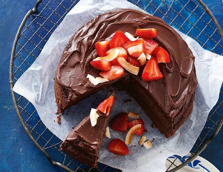 veganer-schokoladenkuchen-ganache-erdbeeren-kokos-geschnitten-torte-cremig-gitter-backpapier